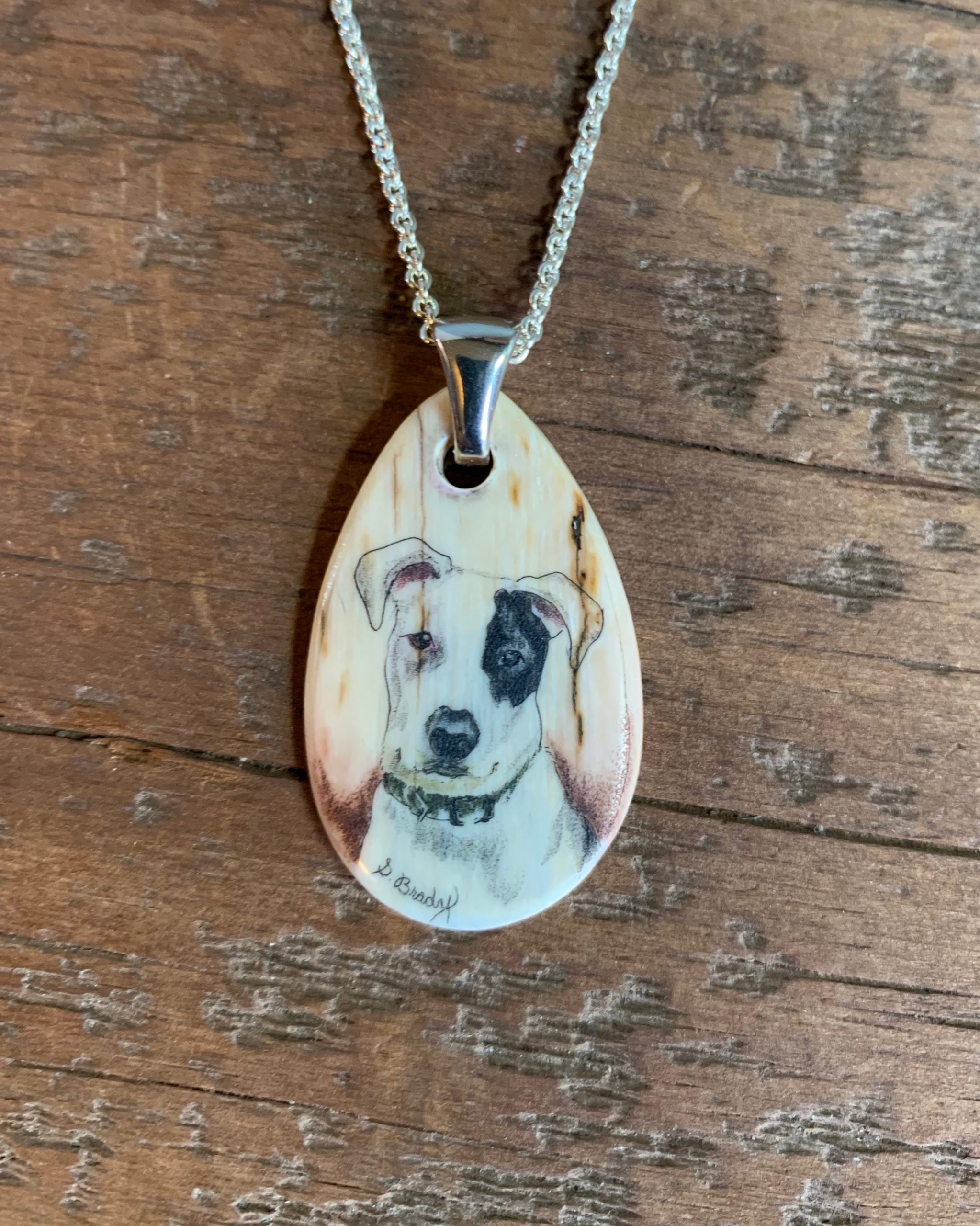 teardrop shaped pendant with dog